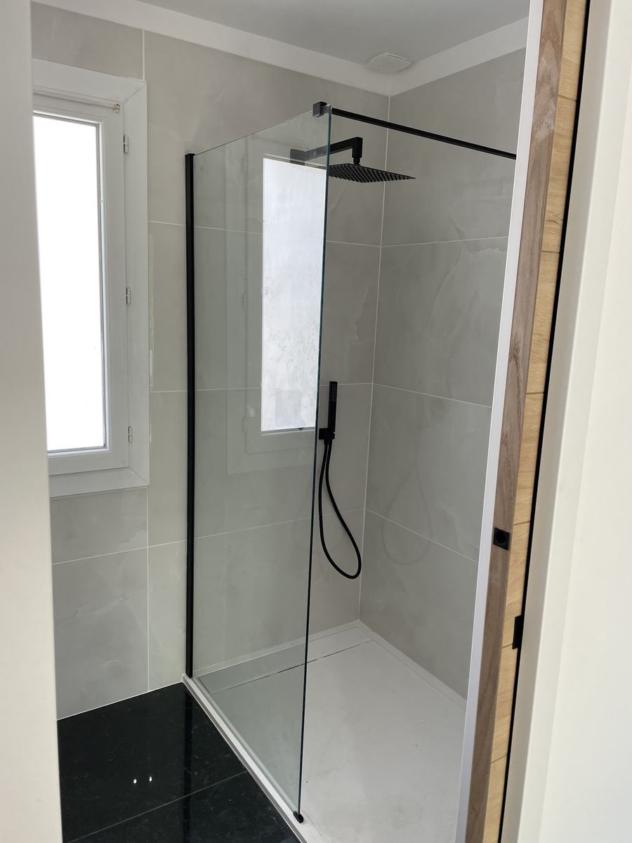 Paroi de douche en verre et ciel de pluie