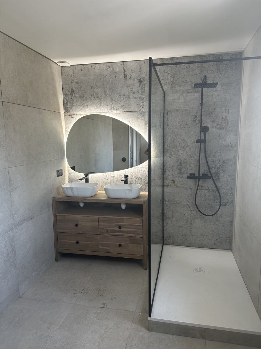Meuble bois, miroir rond et douche vitrée
